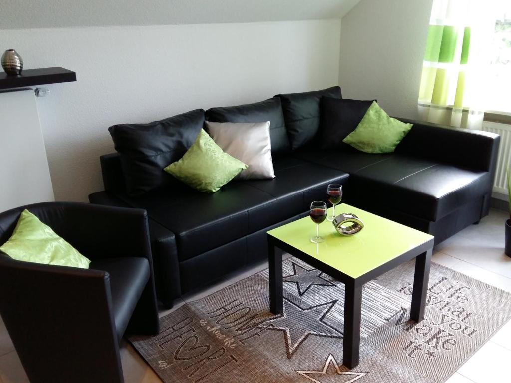 sala de estar con sofá negro y mesa en Ferien in Goslar, Freiers Ferienwohnungen, en Goslar