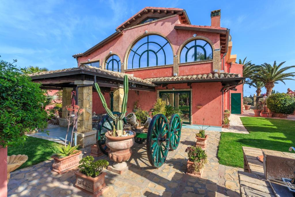 a house with a horse drawn carriage in the yard at Casa Vacanze Villa Flumini in Flumini di Quartu