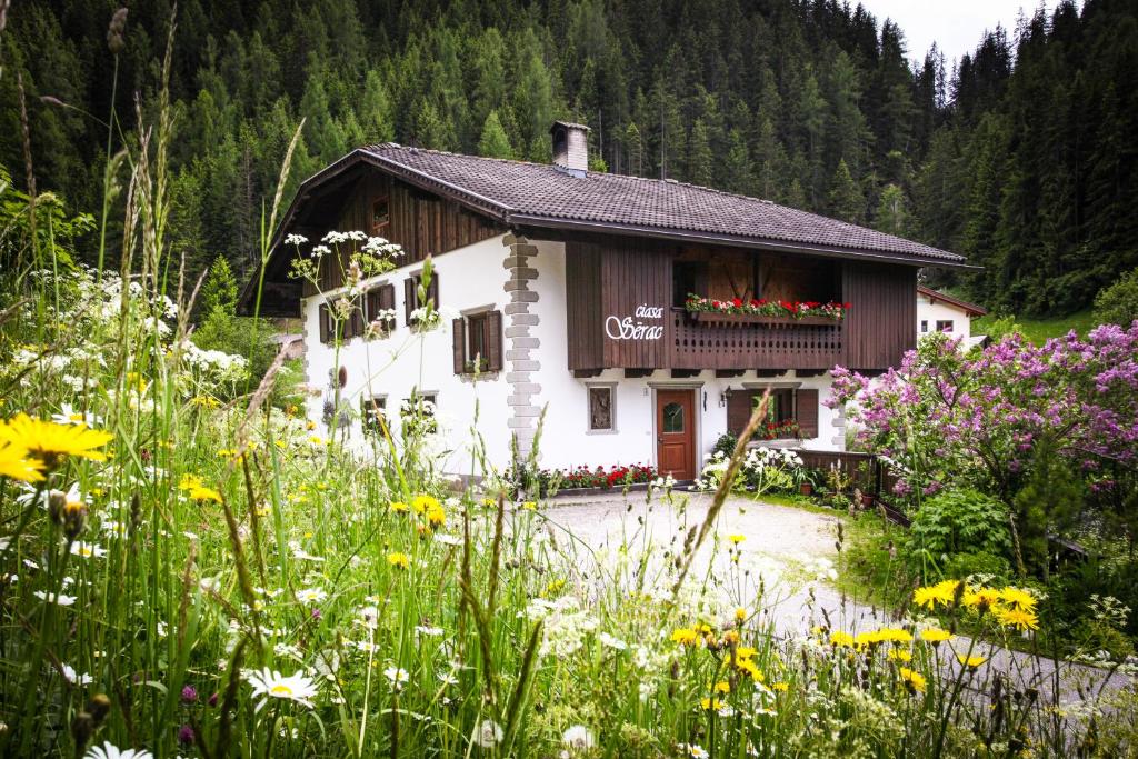 una pequeña casa con flores delante en Casa Serac´, en La Valle