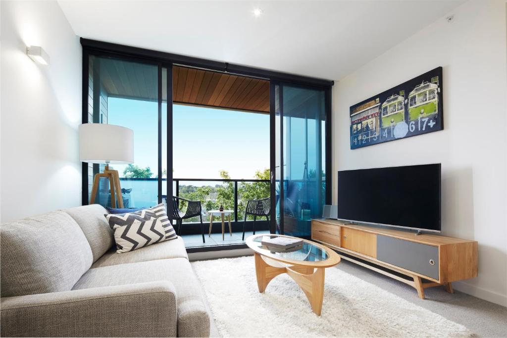 uma sala de estar com um sofá e uma televisão de ecrã plano em Boutique Abode 316 em Melbourne