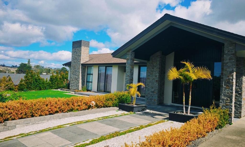 a house with a palm tree in front of it at Tranquil Family Retreat in Red Beach