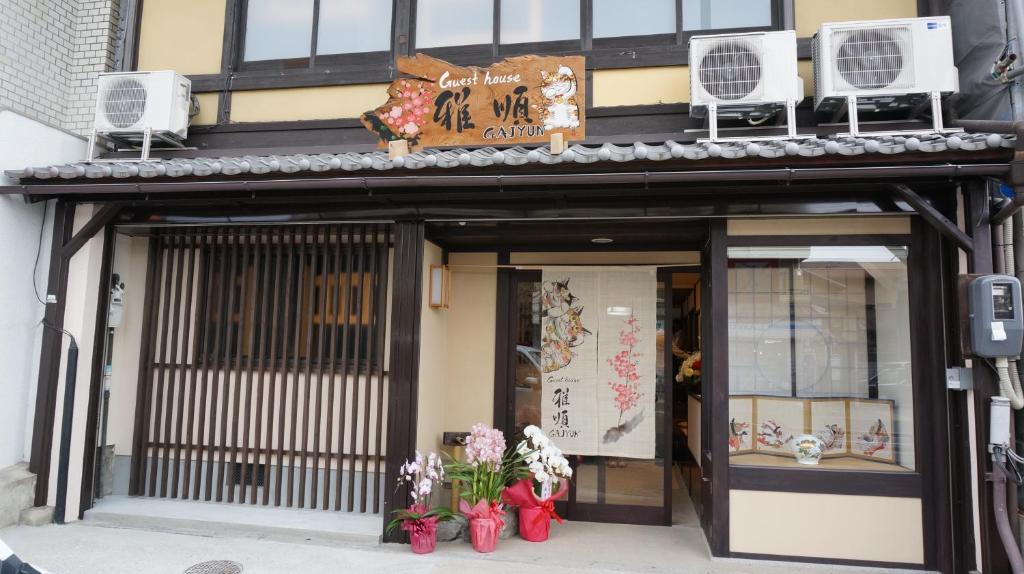 uma frente de loja com flores em frente em Guest House Ga-Jyun em Quioto