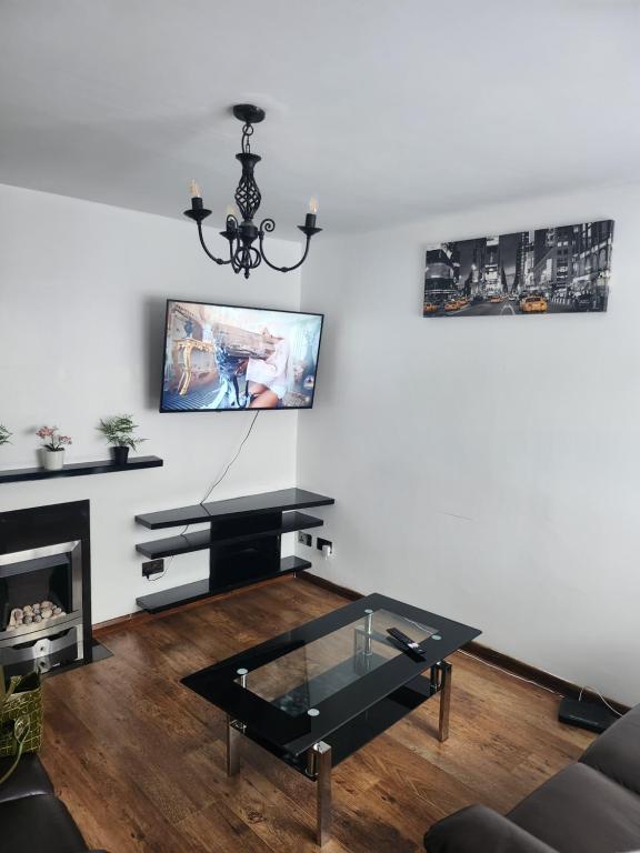 ein Wohnzimmer mit einem schwarzen Couchtisch und einem Kamin in der Unterkunft Modern 3 Bed Free Parking 10 mins walk to station in Dagenham