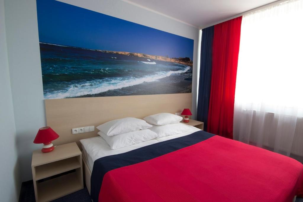 sypialnia z łóżkiem i obrazem oceanu w obiekcie Hotel Czarna Perła w mieście Przejazdowo