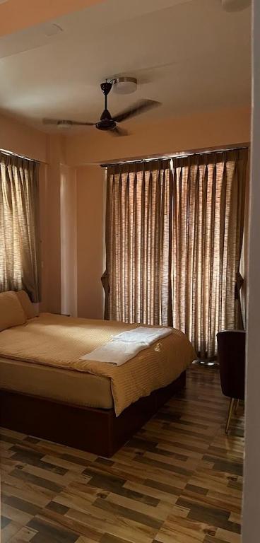 - une chambre avec un lit dans une chambre avec des rideaux dans l'établissement Kathmandu Family Guest House, à Pātan