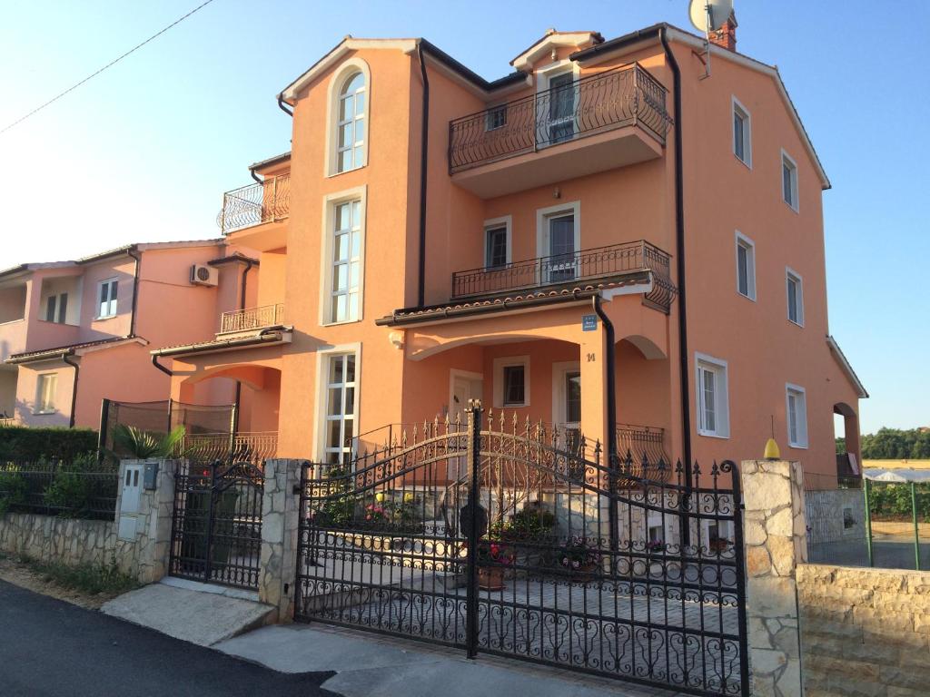 an orange building with a fence in front of it at Ferienhaus Dakovic in Poreč