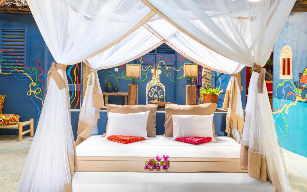 una cama en una habitación con una pared azul en Kaya Kwetu, en Msambweni
