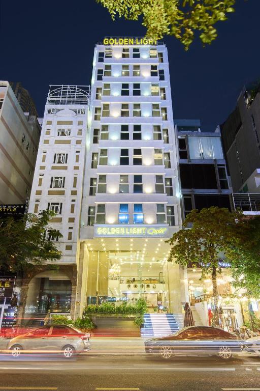 a tall white building with cars in front of it at Golden Light Da Nang Hotel by Elite24 in Danang