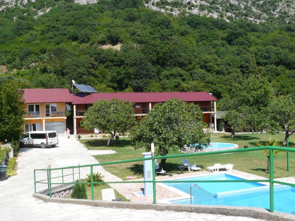 un complejo con piscina y un edificio en Guest House Jadran Pol en Petrovac na Moru