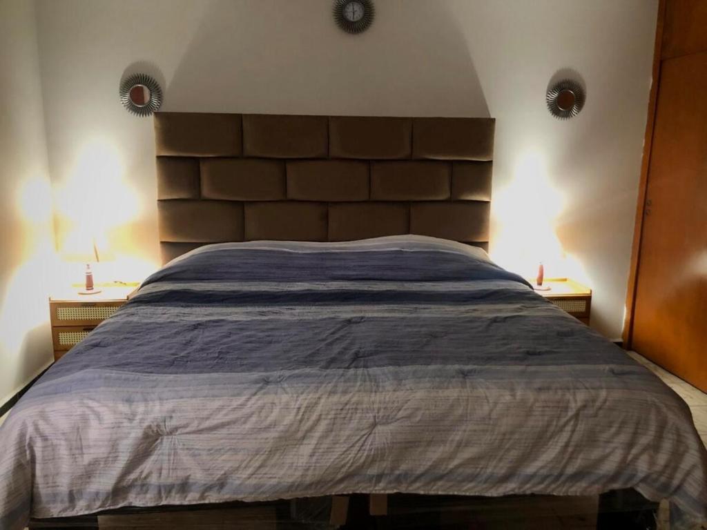 a bed in a bedroom with two lamps on two tables at Casa grande céntrica con alberca in San Luis Potosí