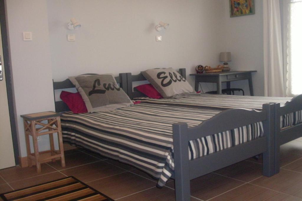 a bedroom with a bed with striped sheets and pillows at La Corraliere Chambres d'Hôtes in Nègrepelisse
