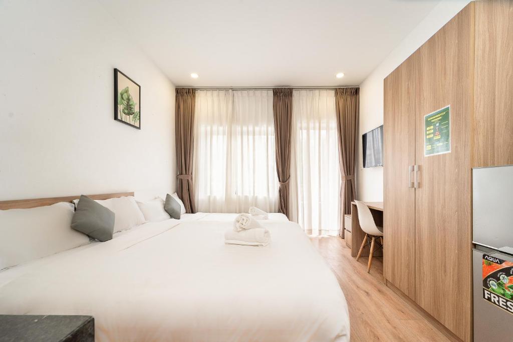 a bedroom with a large white bed and a desk at Daisy House Near Bui Vien - Self Checkin in Ho Chi Minh City