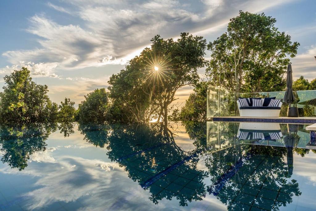a reflection of the sun in a pool of water at Pool House, luxury 2 bedroom with ocean views, pool and sauna in Lennox Head