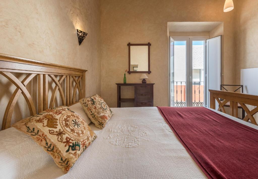 a bedroom with a large bed and a mirror at Apartamento Guzman el Bueno in Tarifa