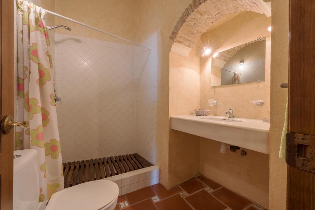 a bathroom with a toilet and a sink and a mirror at Apartamento Guzman el Bueno in Tarifa