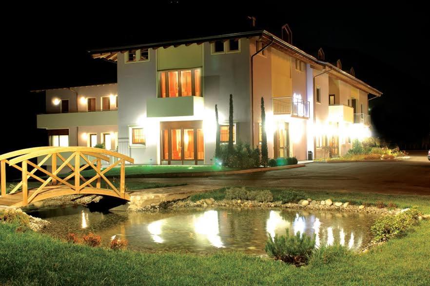 a building with a bridge over a pond at night at Hotel da Rita in Condino