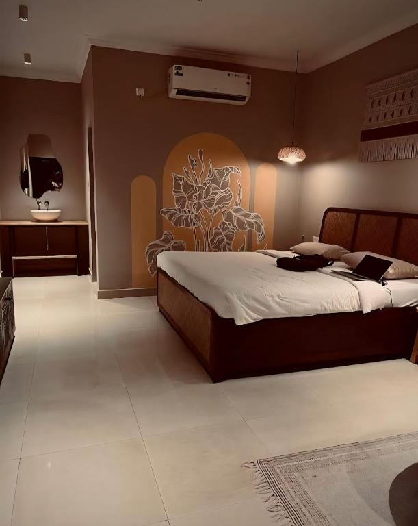 a bedroom with a bed with a painting on the wall at The Twelve Palm Resort in Morjim