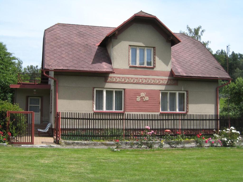 a house with a fence in a yard at Babiččina Chaloupka in Oldřiš