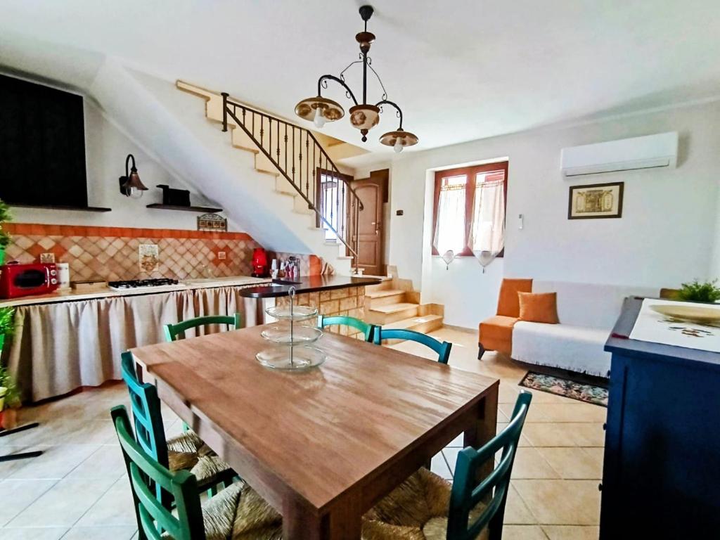 a kitchen and living room with a wooden table and chairs at Polizzihouse in Polizzi Generosa