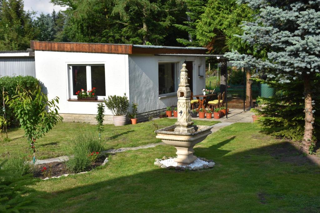 a small house with a fountain in the yard at Ferienhaus Hübner in Leipzig