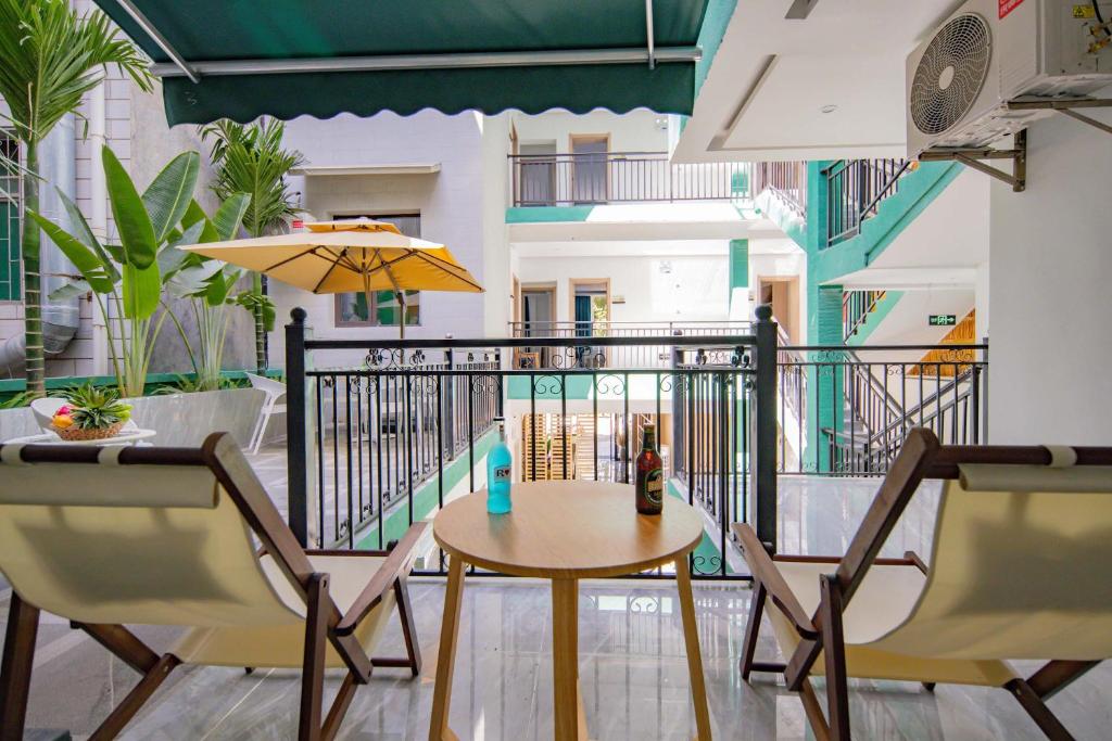 a balcony with a table and chairs on a balcony at Yunzhilu Boutique Hotel in Jinghong