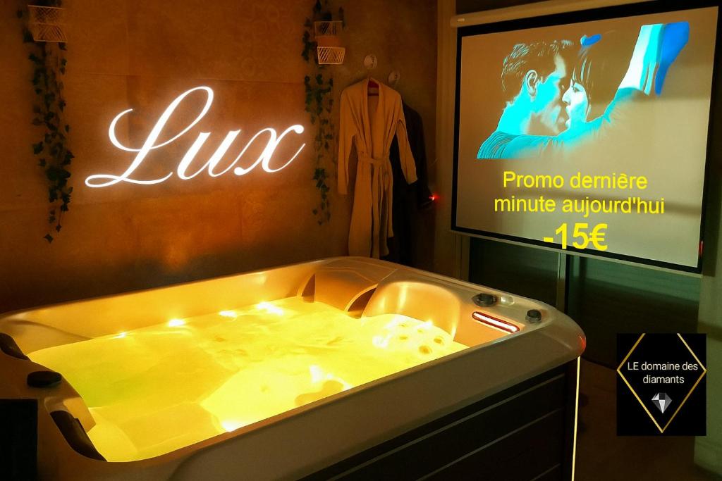 a tub in a room with a tv and a television at Lux, chambre spa privatif Valenciennes in Aulnoy