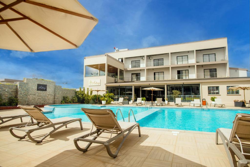 a hotel with a swimming pool and two chairs and an umbrella at Aviavy Hospitality and Special Events in Andakana