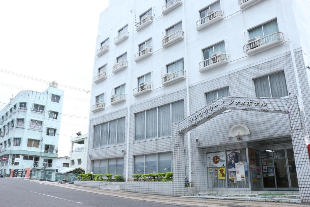 a white building on the side of a street at Sun Flower City Hotel in Setouchi