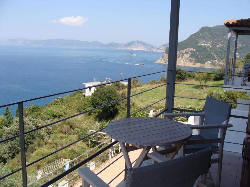 balcón con mesa, sillas y vistas al océano en Sea View Studios, en Skopelos Town