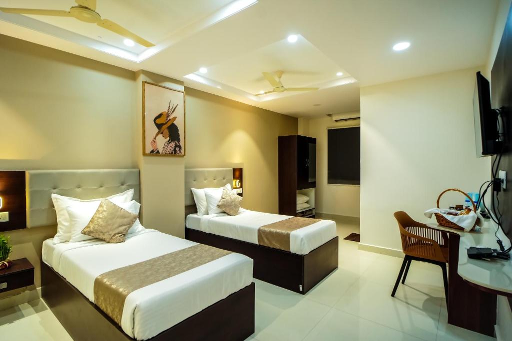 a hotel room with two beds and a television at Felix Inn Boutique Hotel - Manyata Tech Park in Bengaluru