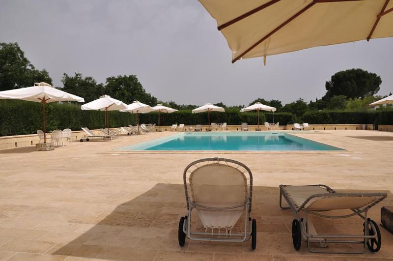 a couple of chairs sitting in front of a swimming pool at L'Orto di Lucania in Montescaglioso