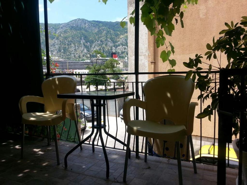 a table and chairs on a balcony with a view at Apartment Kiki in Kotor