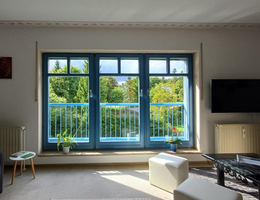 a living room with a large window and a tv at FeWo Oberhof - Tiefgarage und Parkplatz inklusive in Oberhof