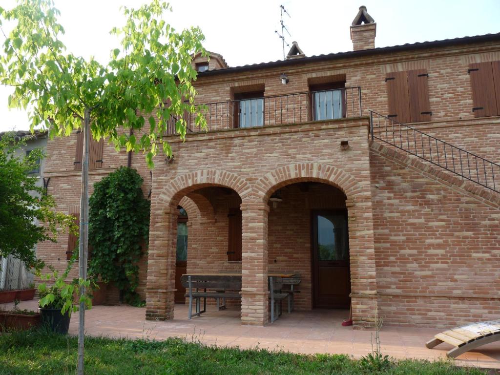 Petritoli的住宿－Agriturismo Serena -Petritoli-，前面有长凳的砖砌建筑