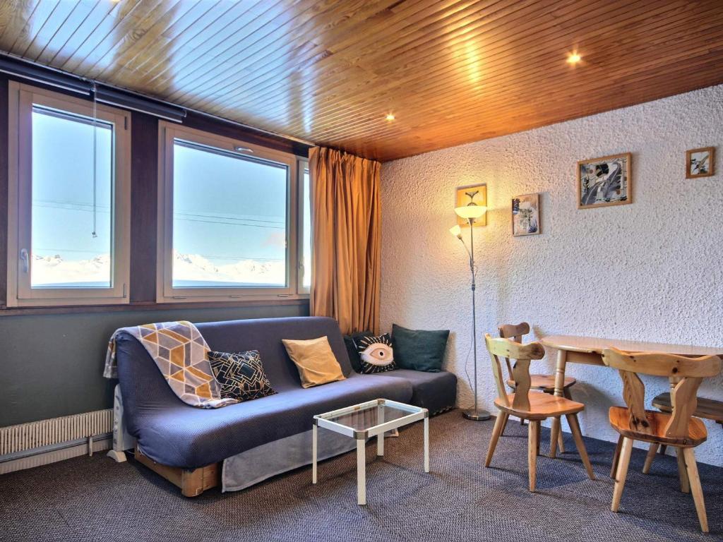 a living room with a blue couch and a table at Grand studio pour 3 personnes, au pied des pistes, tout proche des commerces avec Wifi - FR-1-455-166 in La Plagne