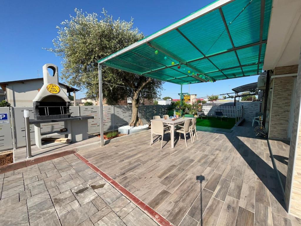 Un patio con parrilla y mesa y sillas. en Eden Suite, Patio & BBQ near Lake Garda, en Castiglione delle Stiviere