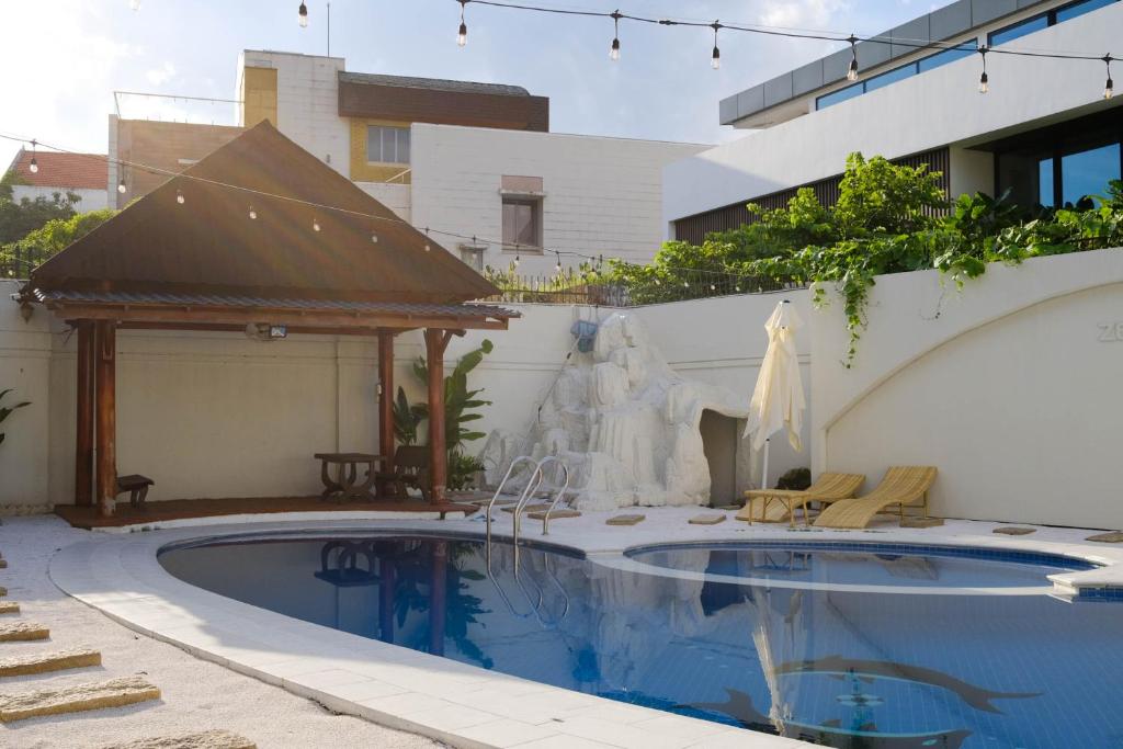 Zeus Living - Oasis Villa in Thao Dien في مدينة هوشي منه: مسبح وامامه نافورة