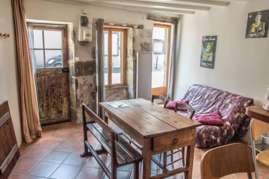 a living room with a wooden table and a couch at Maison de bourg Cébazat in Cébazat