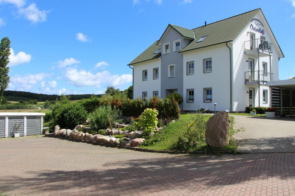 ein großes weißes Haus mit einem Garten davor in der Unterkunft Appartementhaus Ostseeluft in Lohme