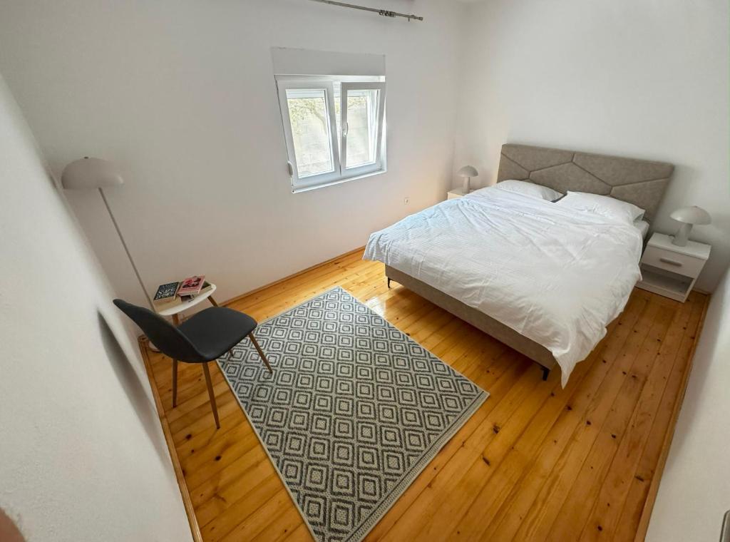 a bedroom with a bed and a chair and a rug at Vele apartment in Mostar