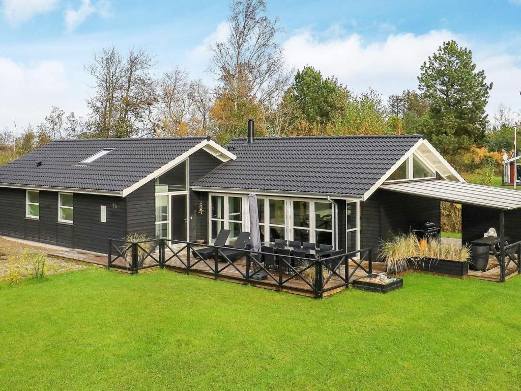 a black house with a large yard at 10 person holiday home in Jerup in Jerup