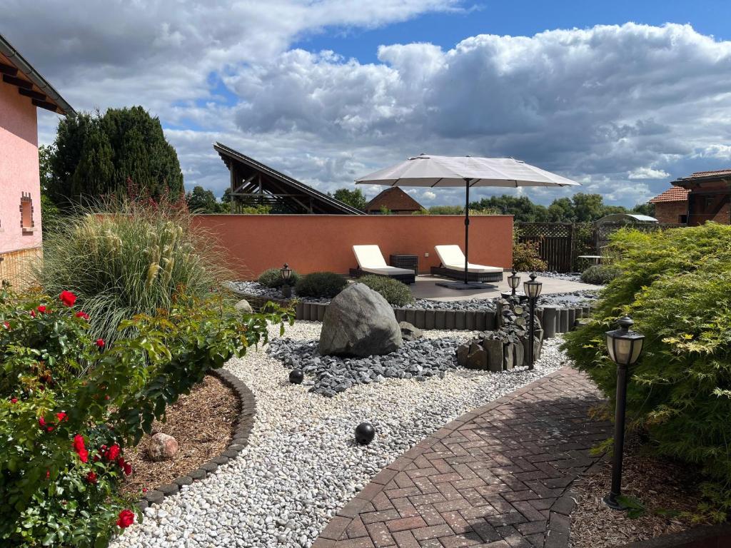 a garden with a patio with an umbrella and chairs at Ferien- & Monteurswohnung Krüger Werra Suhl Tal in Raßdorf