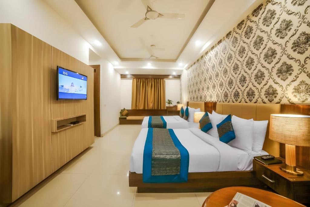 Una habitación de hotel con una cama y un televisor de pantalla plana. en Hotel Almati Inn - Near Delhi Airport, en Nueva Delhi