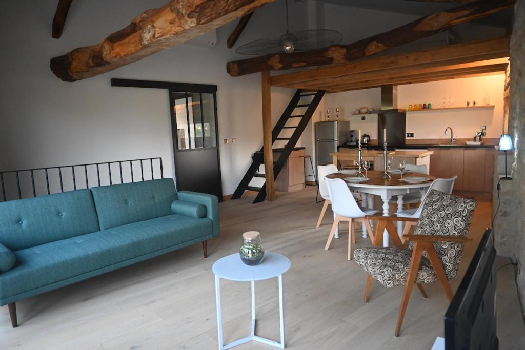 a living room with a blue couch and a table at Gîte au cœur des Bastides Albigeoises in Le Verdier