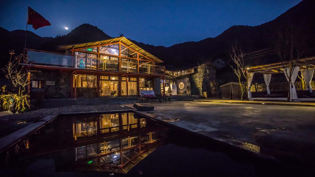 una casa grande con un charco de agua por la noche en Manshanju Forest Healing, en Lishui