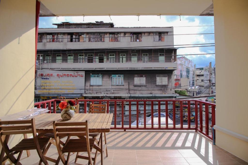 a balcony with a table and chairs and a building at The Open House Cafe and Hostel in Bangkok