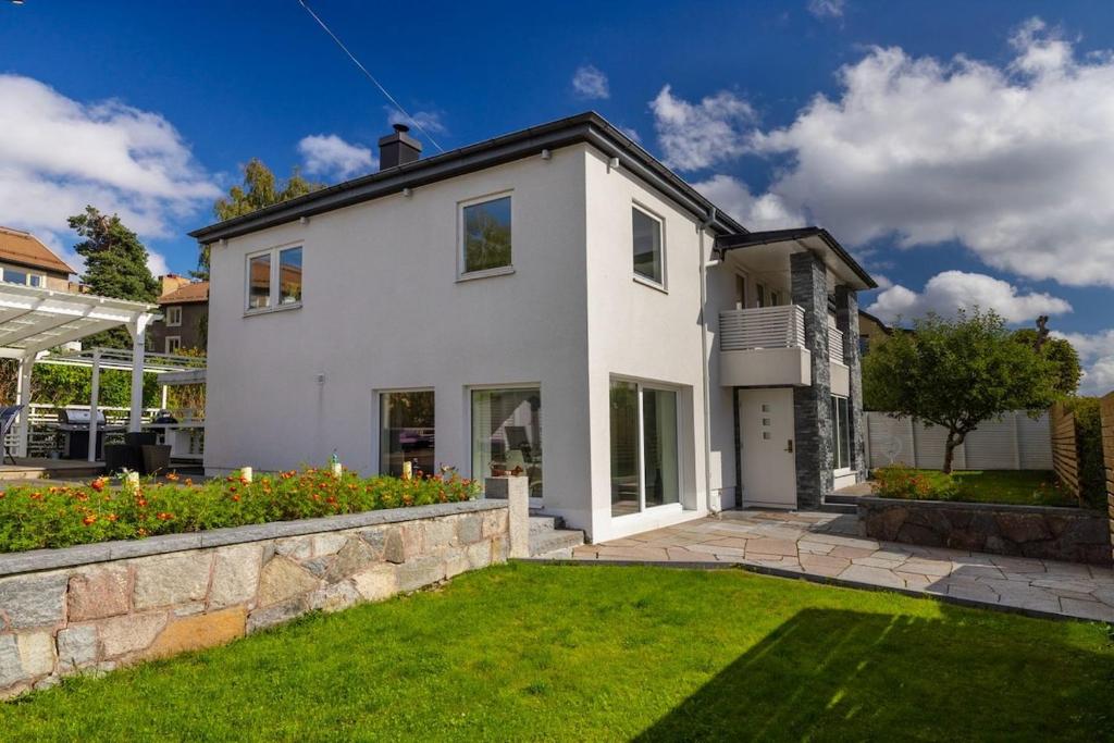 ストックホルムにあるComfortable & spacious villa near Stockholm cityの緑の芝生のある庭のある白い家