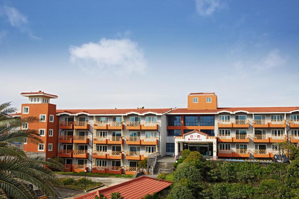 an apartment building with orange and white at 제주토비스콘도 신관 in Kwakchi-ri