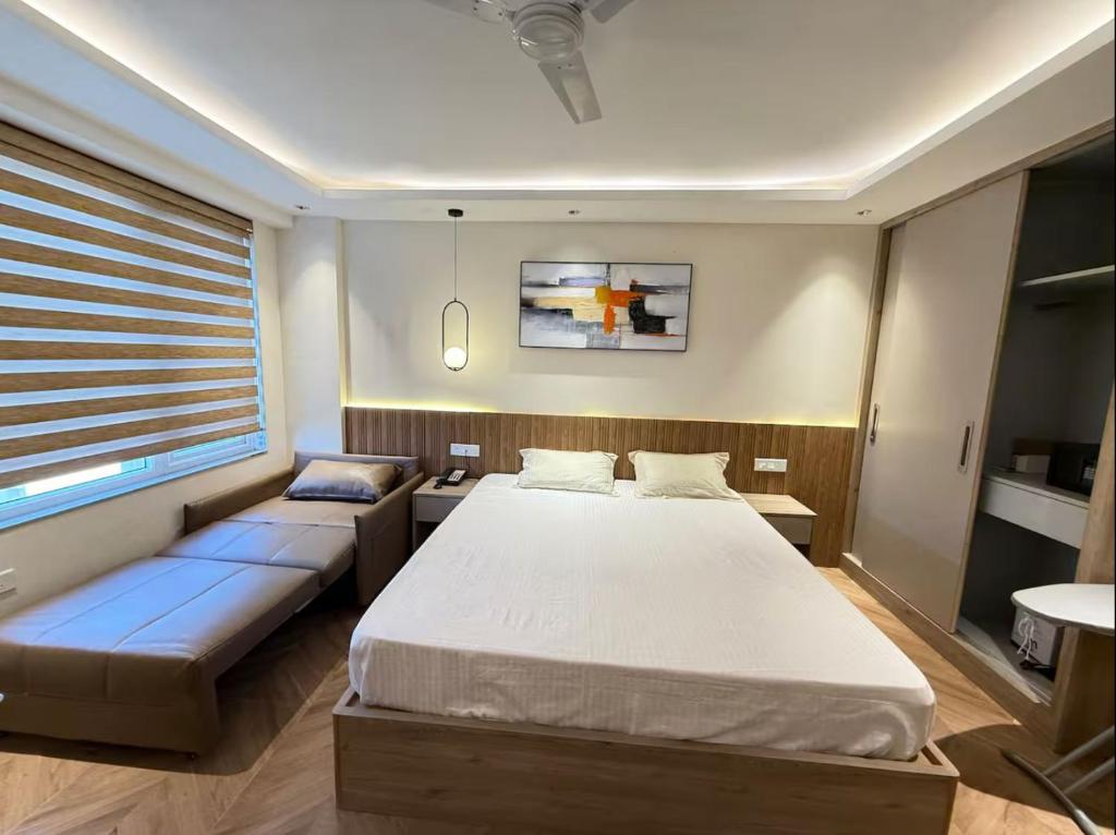a bedroom with two beds and a couch in it at Keshar property in Greater Noida