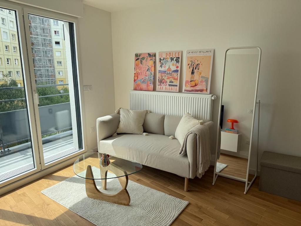 un salon avec un canapé et une table en verre dans l'établissement Laplace - 5 min from Paris and Parking, à Arcueil